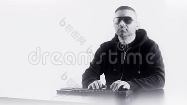 戴太阳镜的人在电脑键盘上打字，白色复印空间